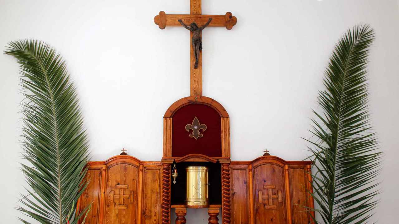 Christians Celebrate Palm Sunday Indoors with Palm Symbols Outside
